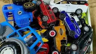 A full box of cars, cool cars, a blue tractor, a tractor, jeeps, a sports car and a few more cars.